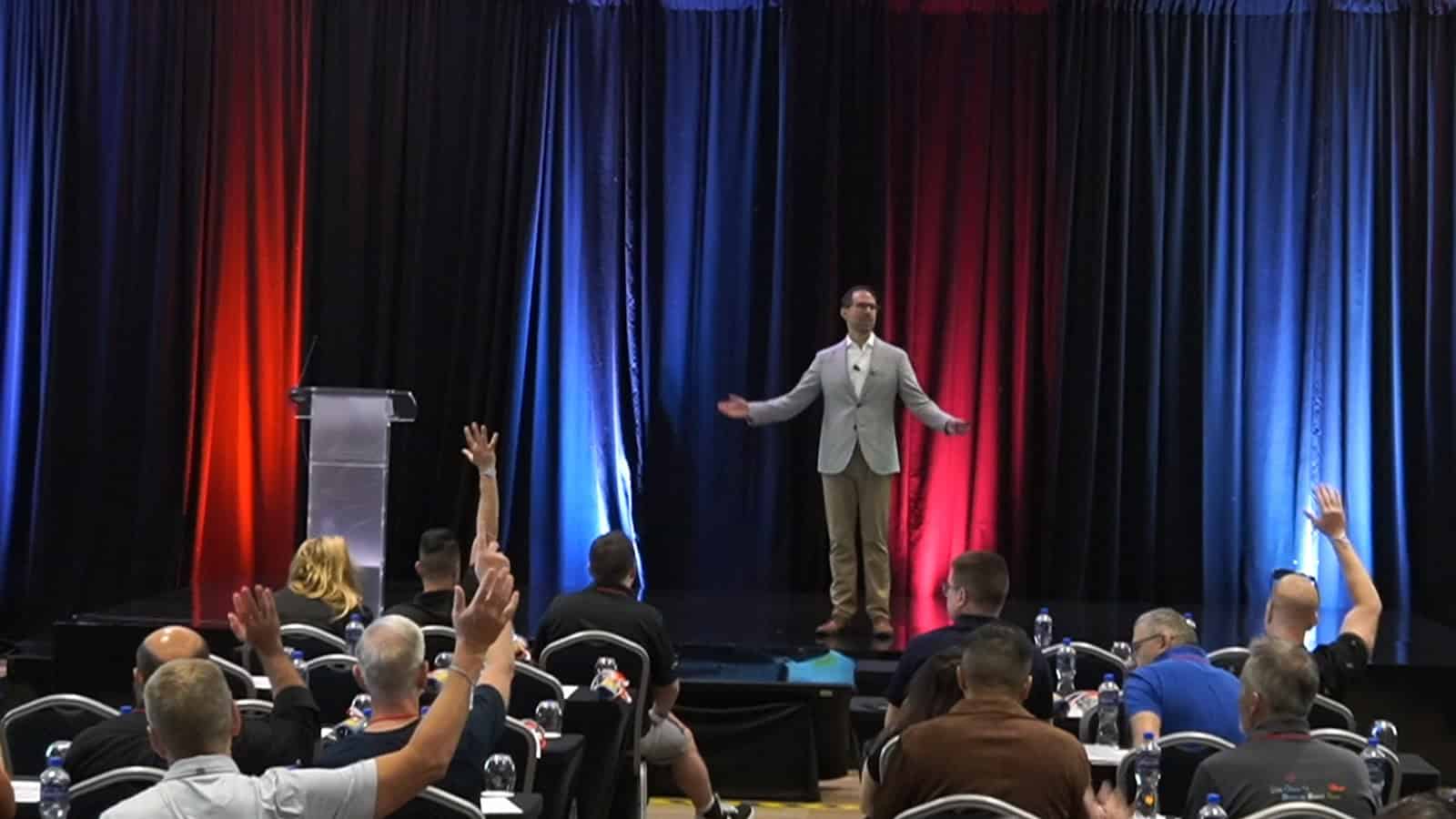 Business speaker presenting to engaged audience at a conference.